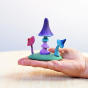 Hand holding the Bumbu rainbow enchanted mushroom toys over a wooden worktop 