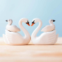 2 Bumbu wooden swan toys face to face with 2 little cygnet figures on their backs
