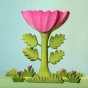 The Large Pink Flower by Bumbu is an impressive wooden flower with four leaves and a rich pink bloom, it stands on a green wooden base and it's surrounded by wooden grass, with a blue background. 