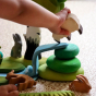 A child plays with the Bumbu Wooden Waterfall and other Bumbu wooden toys to create a wildlife scene.