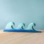Bumbu Wooden Waves. The toy sits on a wooden surface against a blue background. The three wave piece is shown.
