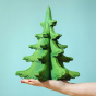 Person holding the Bumbu Large Green Sugar Pine Tree in their hand pictured on a blue background