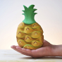 Close up of the Bumbu eco-friendly wooden stacking pineapple toy set on a persons hand in front of a white background