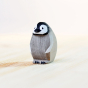 Bumbu handmade eco-friendly miniature wooden penguin chick toy figure stood on a wooden work top in front of a white background