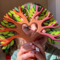 A child looking through the heart cut out, in the centre of the Bumbu Wooden Heart Tree