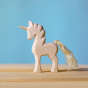 Bumbu Natural Wood Unicorn placed on a wooden surface with a blue wall in the background