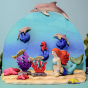 Bumbu wooden Mermaid toy posed in an aquatic scene with the Bumbu dolphin, seahorse, fish, starfish, and seaweed.