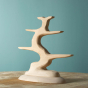 Bumbu handmade natural wooden bird tree toy on a wooden worktop in front of a blue background