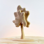 Close up of the Bumbu handmade natural wooden birch tree toy on a wooden table in front of a grey background