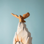 Close up of the Bumbu plastic-free wooden eagle figure on top of a wooden rock