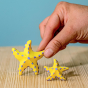 Bumbu Yellow Starfish Set next to a hand for size reference.