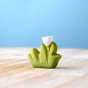 Bumbu children's small wooden grass with white flower toy on a wooden worktop in front of a blue background