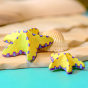 Bumbu wooden toy Yellow Starfish Set posed in a beach play scene.
