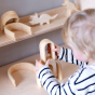 Bumbu Natural Wooden Stacking Arches. A child stacks the arches in a home setting.