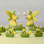 Two Bumbu Woodland Fairies look like they're happily having a discussion  among small yellow flowers
