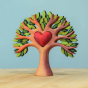 Bumbu Wooden Heart Tree. A beautifully crafted Wooden Tree with light brown branches, light and dark green leaves, with a removable wooden red heart in the centre. The tree is displayed on a wooden table with a blue background