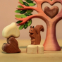 A closer look at the Bumbu Squirrel sitting on a white wooden heart, with the Bumbu Heart Tree in the background