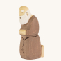 Bumbu Handmade Wooden Joseph figure kneeling down, on a cream background. Joseph has a light brown outfit with a dark brown belt, and a white beard.