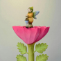 The Bumbu Wooden Winged Elf holding their Wooden lamp and stood on top of a Large Bumbu Pink Flower, with a pale background