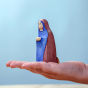 Bumbu Handmade Wooden Mary Figure kneeling down on an adults hand. Mary wears a royal blue and red dress with a small star detail.