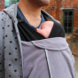 Close up of Man stood in front of a brick wall wearing the close caboo baby carrier fleece cocoon liner 