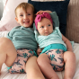 Boy and baby girl wearing Pop-in light pink Ferret velcro Nappy all in one nappy with green trim 