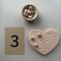 The Coach House Heart Fine Motor Board, a number '3' card and a bowl of wooden loose parts. 