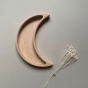 Crescent moon shaped wooden sorting tray for loose parts paly by Coach House.  Grey background with dried flower sprig.
