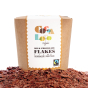 Box of Cocoa Loco organic fairtrade milk hot chocolate flakes on top of a large pile of chocolate flakes