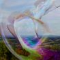 Close up of a Dr Zigs giant bubble floating over the countryside