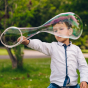 Young boy making a giant bubble with the Dr Zigs eco-friendly bubble hand wand