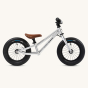 Side of the Early rider silver kids balance bike on a beige background
