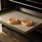 Ecoliving Reusable Silicone Baking Liner on a baking tray with two crumpets in an oven