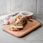 Sliced bread and white tea towel on top of an Ecoliving sustainable wooden chopping board