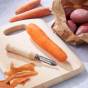 Ecoliving Wooden Potato Peeler on a chopping board next to a carrot