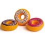 A three pack of Erzi wooden play food toy iced doughnuts with three different toppings, on a plain background.