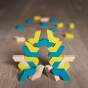 Erzi stacking flickflack blocks in a geometric tower on a wooden floor