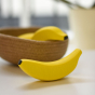 Erzi Banana Wooden Play Food in front of a Respiin bowl of toy bananas