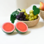 Erzi Half Watermelon Wooden Play Food Fruit next to a Respiin wnatural bowl of wooden bunches of grapes