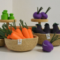A Respiin bowl filled with Erzi Carrot Wooden Play Food in front of play kitchen wooden scales.