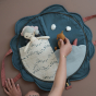 Inside the Fabelab Organic Carry Purse - Shell. Image shows a child playing with the inside activity pockets using a toy seahorse and fabric doll (doll not included)