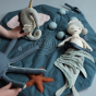 Close up of child playing with the Fabelab Underwater Activity Blanket with a toy mermaid hiding in the seaweed