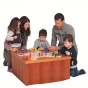 Family gathered around a small table playing the Fagus wooden enchanted playground board game on a white background