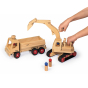 Hands moving the Fagus wooden digger toy over the Fagus wooden tipper truck on a white background