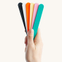 Hand holding a set of FixIts coloured mouldable plastic strips on a beige background