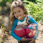 A child wears the Frugi Switch Character Crawlers - Honeysuckle / Hedgehog in an outdoor setting.
