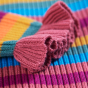 Material and cuff detail on the Frugi Zoe Knitted Jumper - Rosehip Rainbow Stripe.