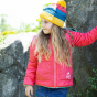 A young child wears the Frugi Reversible Toasty Trail Jacket - Acorns / Honeysuckle in an outdoor setting.