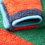 Cuff and material detail on the Frugi Coral Reversible Snuggle Fleece - Paprika Rainbow Stripe / Indigo.