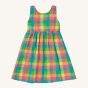 Frugi Organic Arya Summer Dress - Summertime Check. A lightweight organic cotton, short sleeved, dress with a colourful checked all over print, gathered skirt for twirling, comfy cross-over straps and button fastenings at the back. On a cream background.